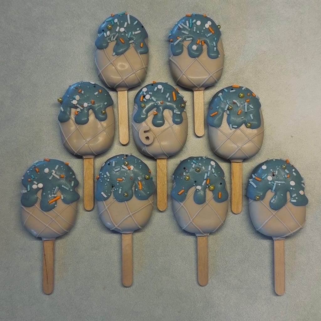 Soft blue-drip cakesicles with gold pearl sprinkles